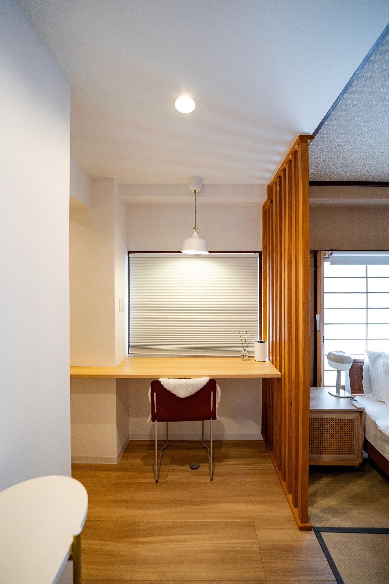Desk nook with a red chair under a shuttered window