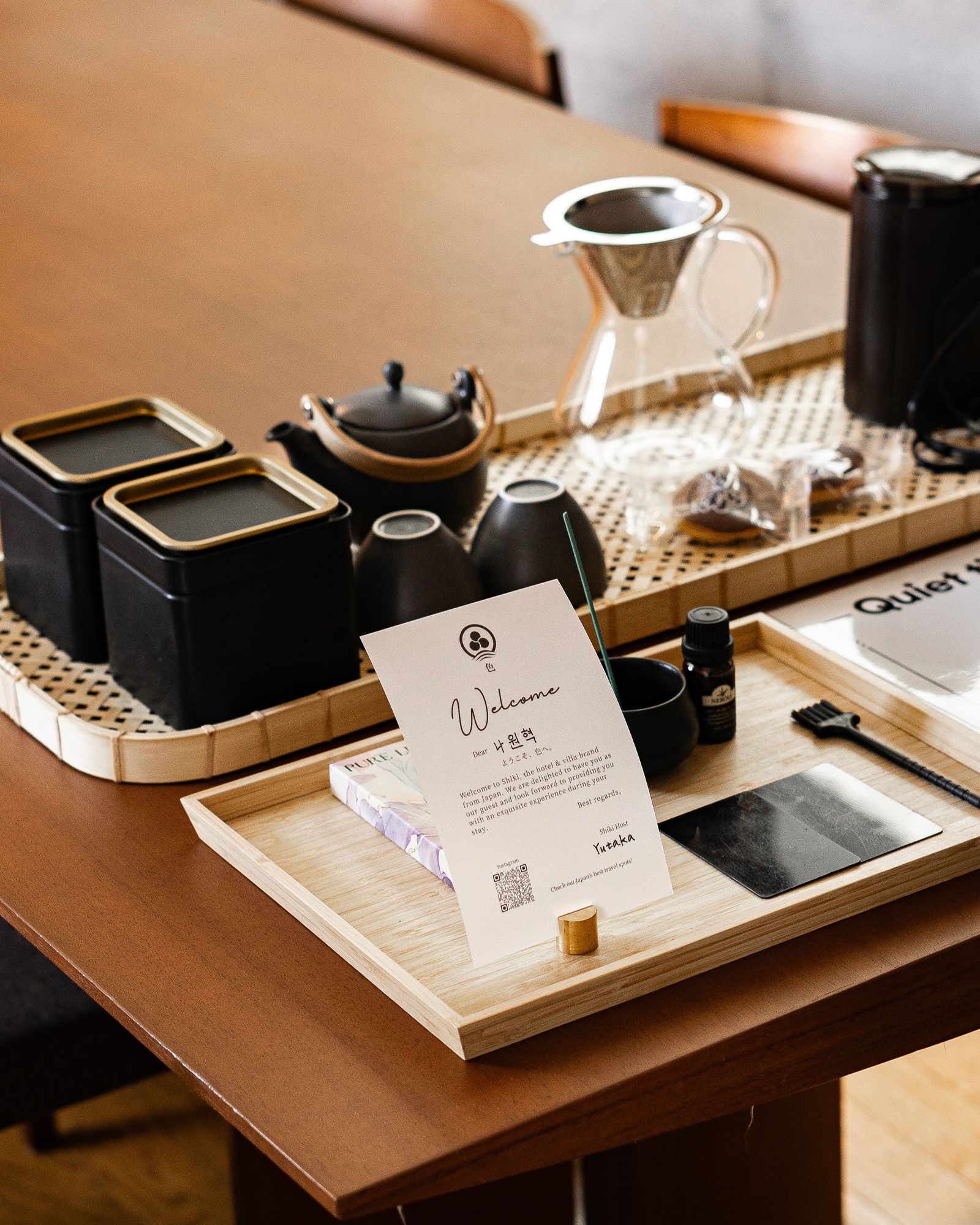 Welcome tray with teaware and a handwritten card on a wooden table