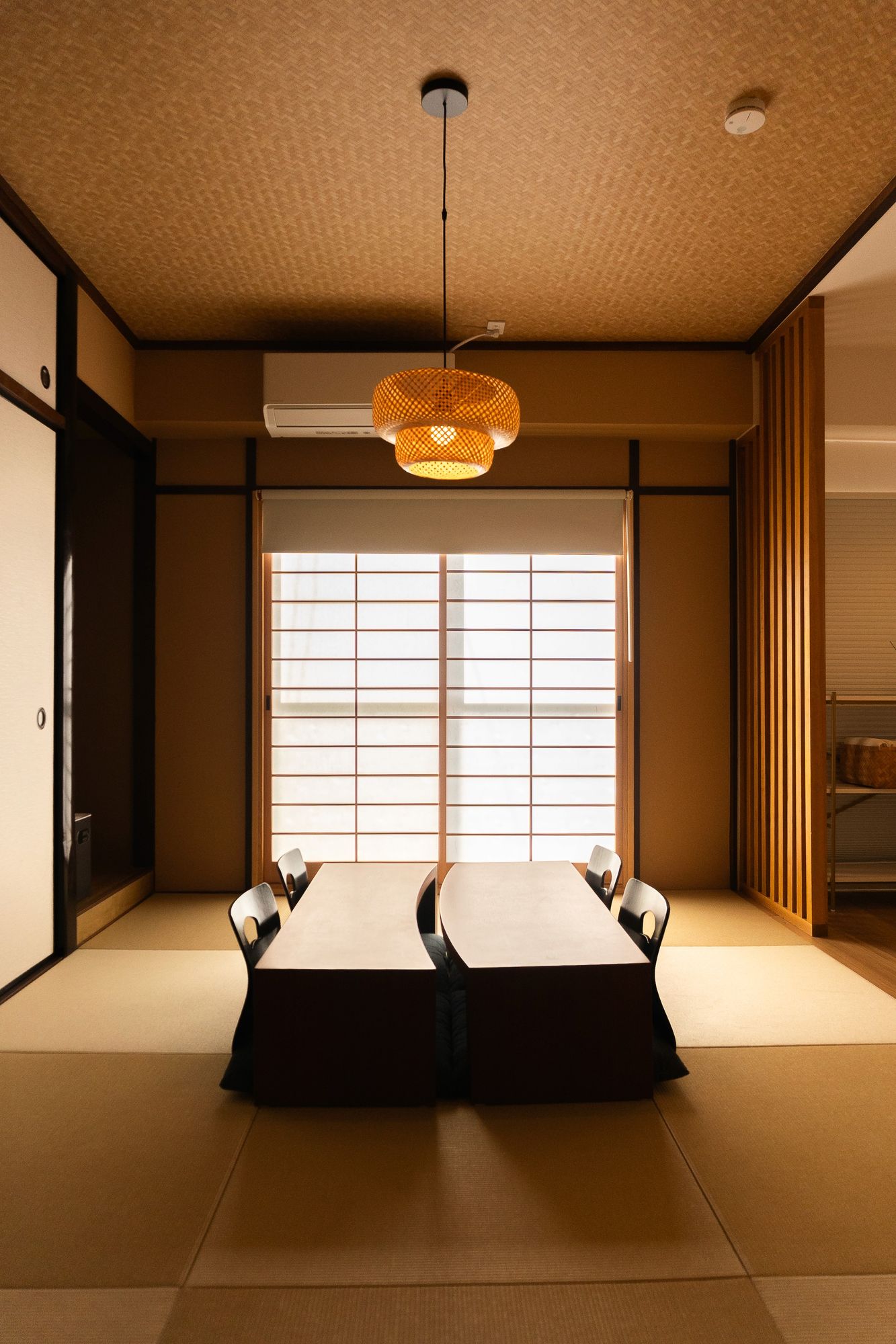 Tatami room with twin futons and an amber pendant lantern