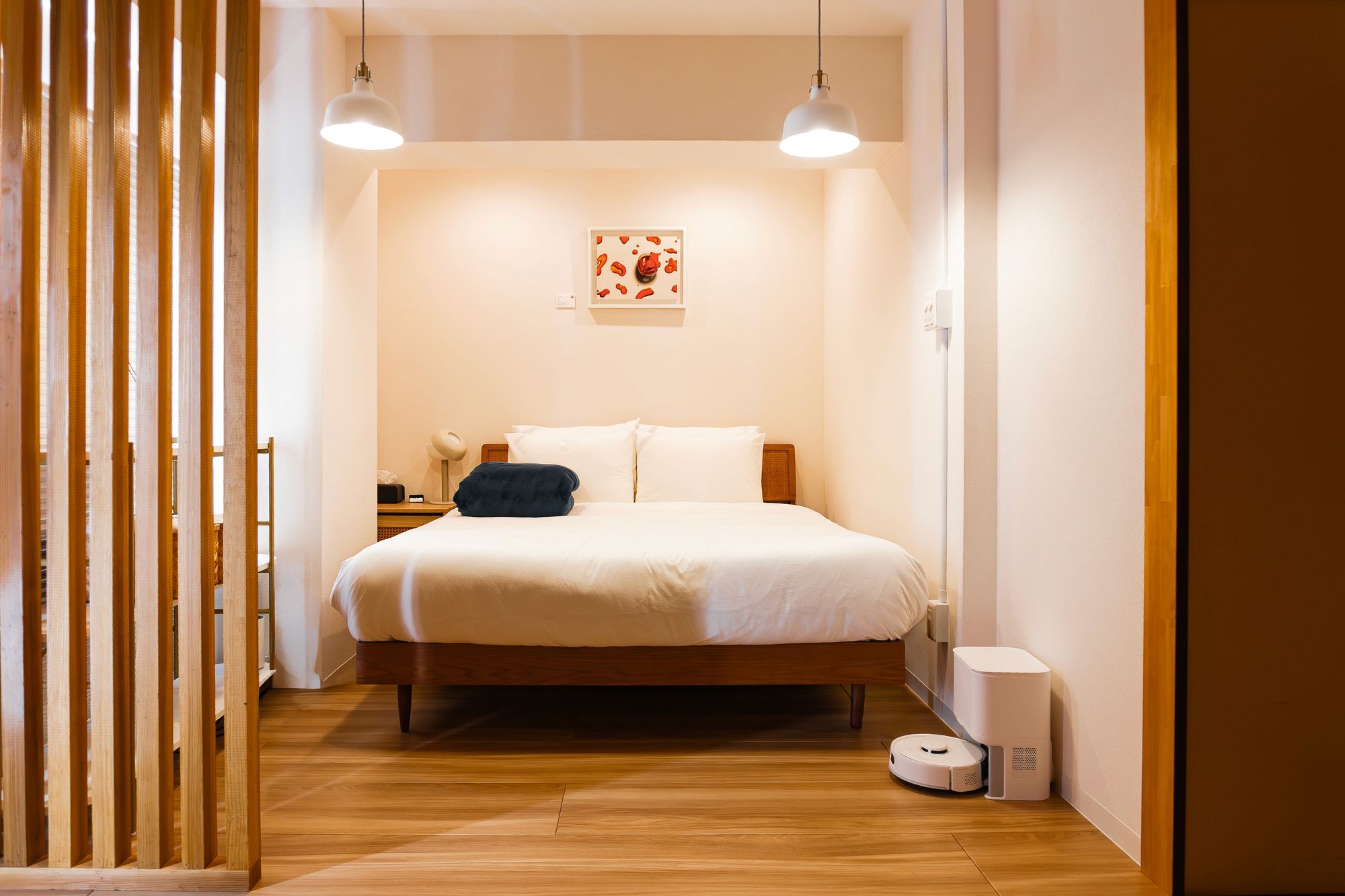 Guest bedroom at Shiki Villa Beppu seen past a vertical wooden slat screen