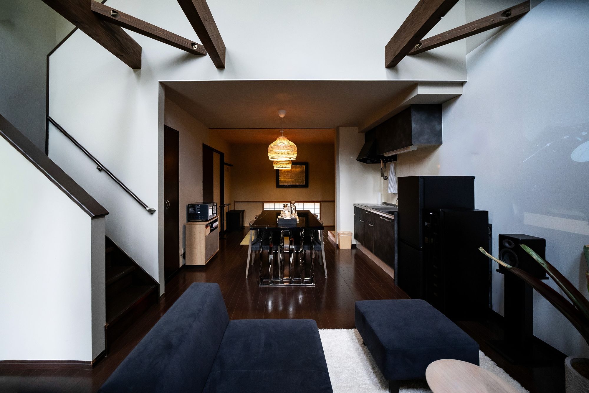 Split-level lounge with navy sofas beneath exposed beams